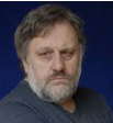 Man with beard looking serious against dark background.