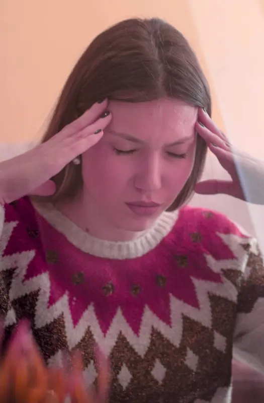 Woman with headache holding her temples.