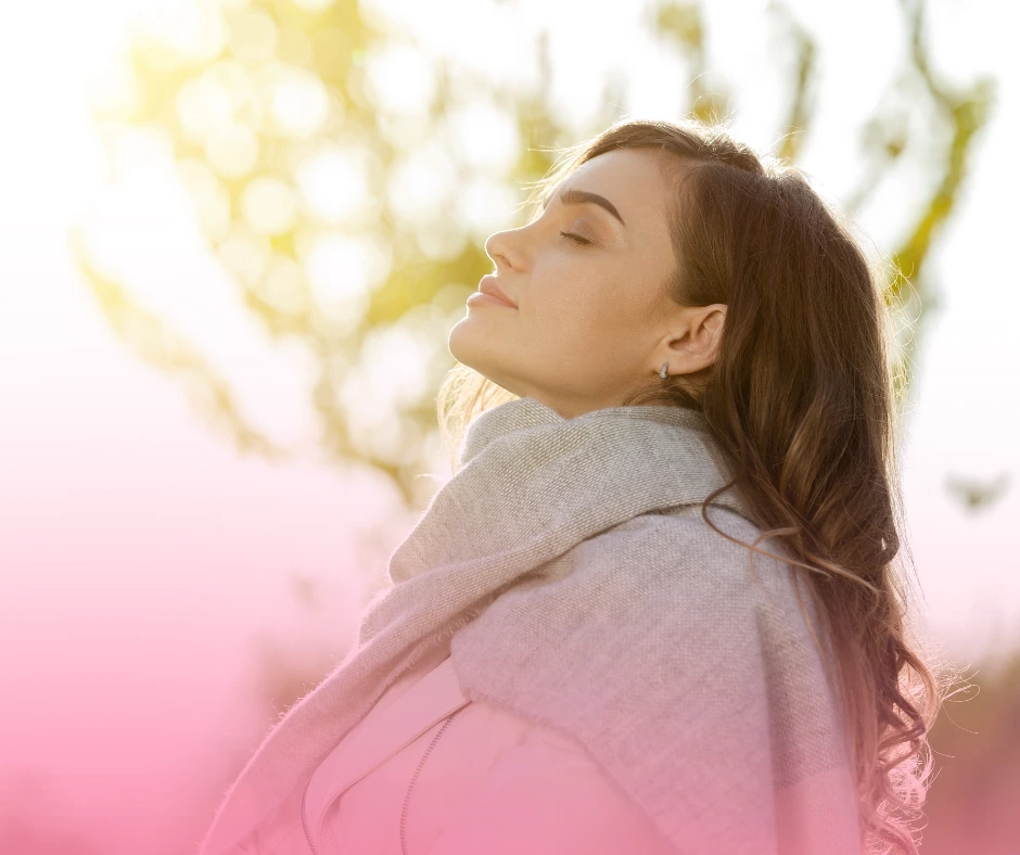 Woman enjoying sunlight with eyes closed.