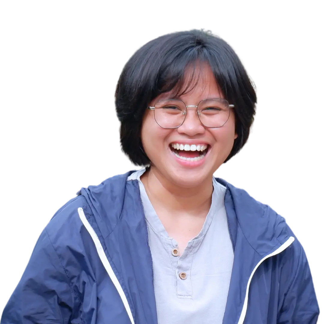 Person smiling joyfully, wearing glasses and blue jacket.