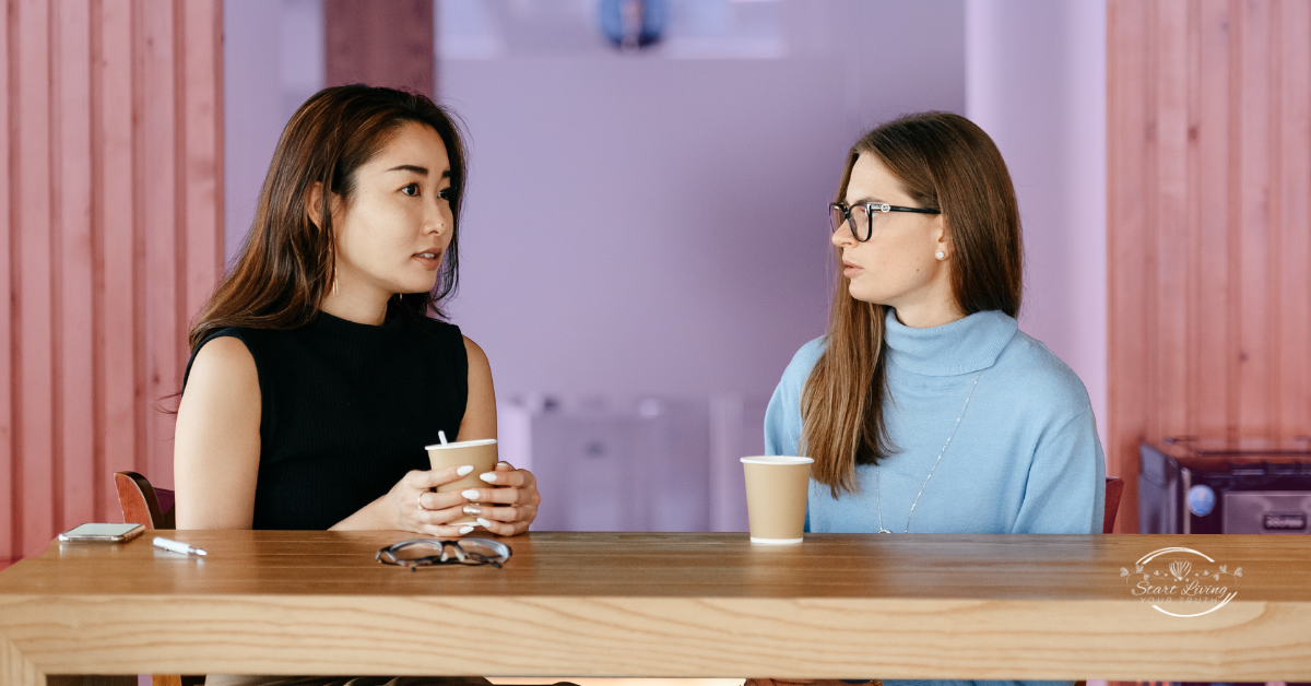 Two women having a conversation over coffee.