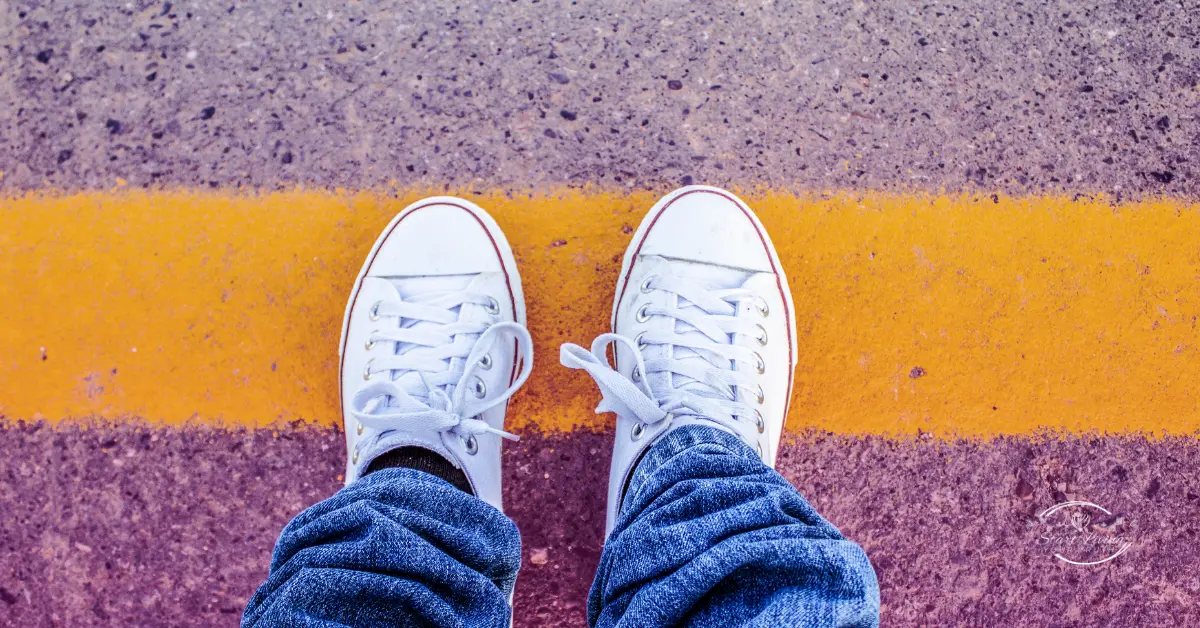 White sneakers on colourful road surface.