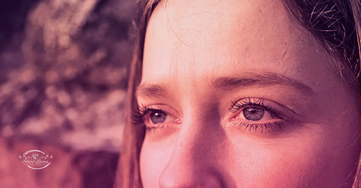 Close-up of woman's eyes in pink light