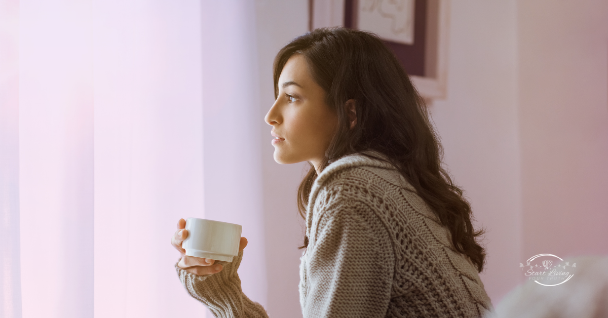 Woman enjoying a warm drink by the window.