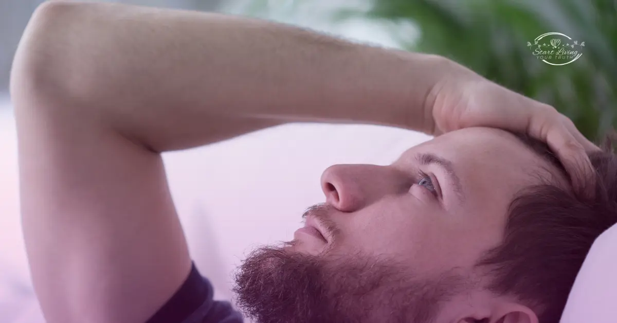 Man lying down, looking thoughtful and relaxed.