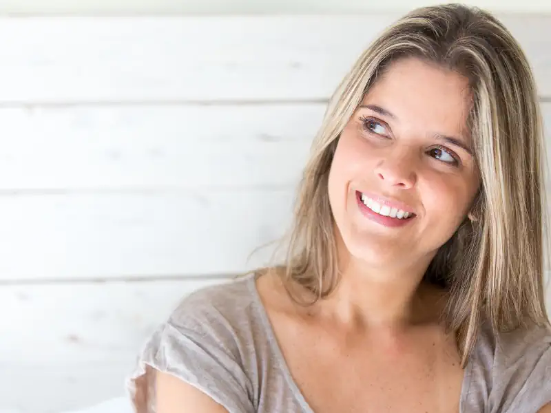 Smiling woman looking away indoors.